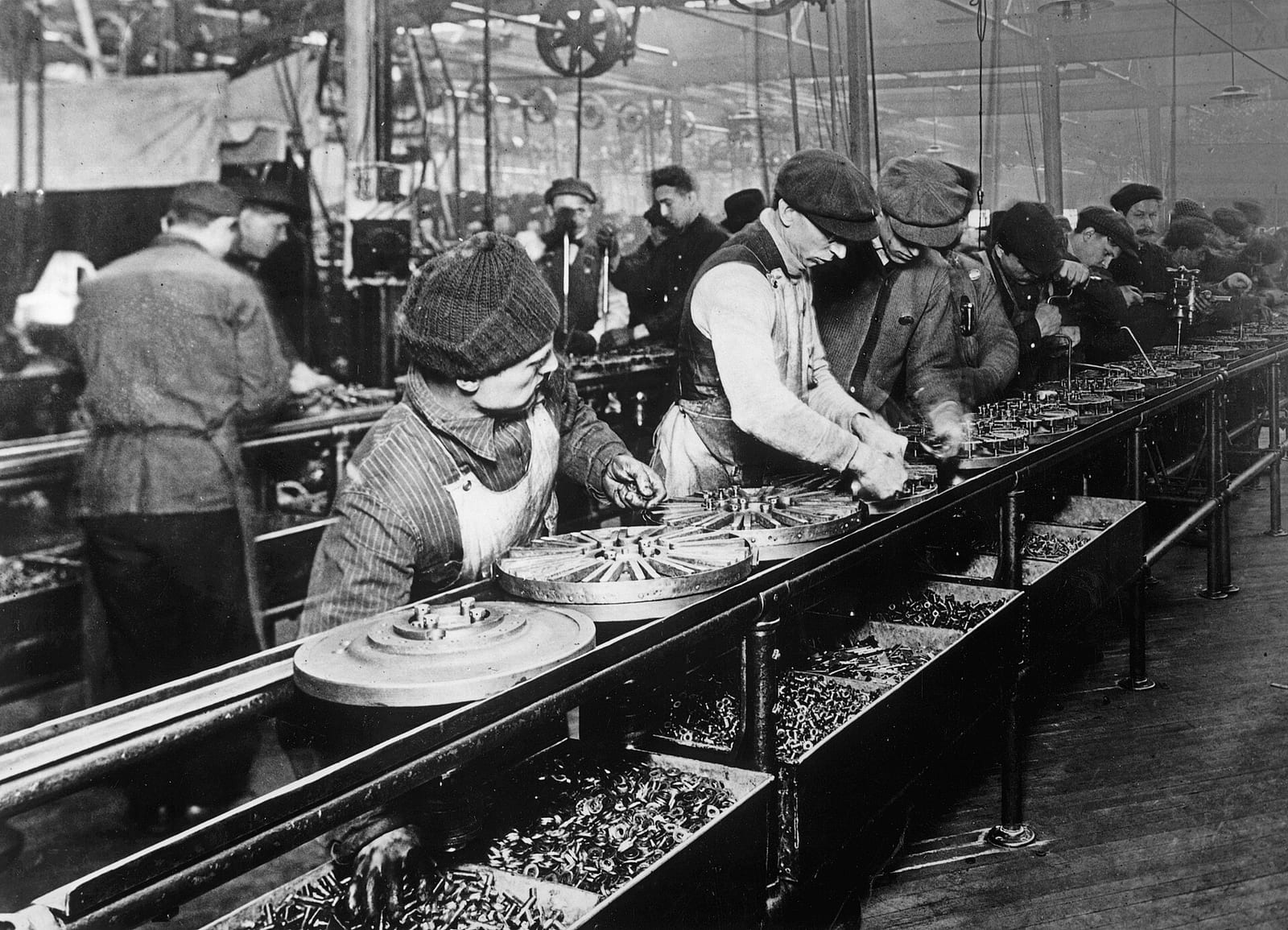 Obreros ensamblando piezas en una línea de producción de Ford en 1913.